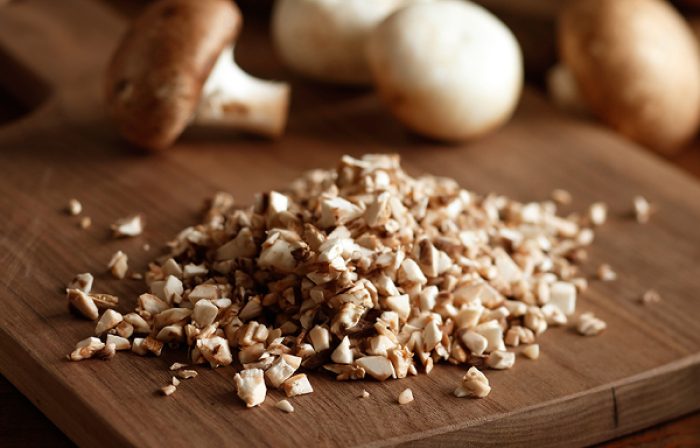 Diced mushrooms on a cutting board.