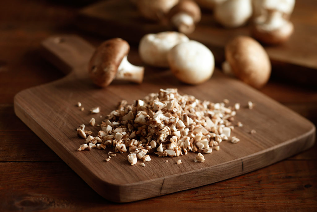 Diced mushrooms on a cutting board.