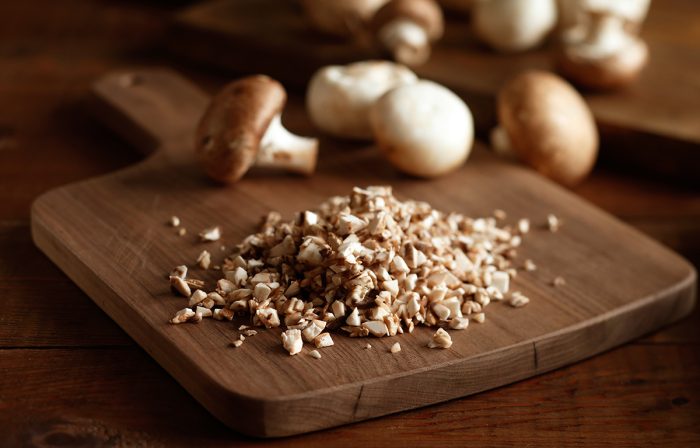 Diced mushrooms on a cutting board.