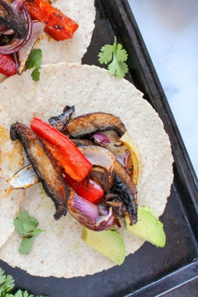 Three mushroom fajitas served on a sheetpan.