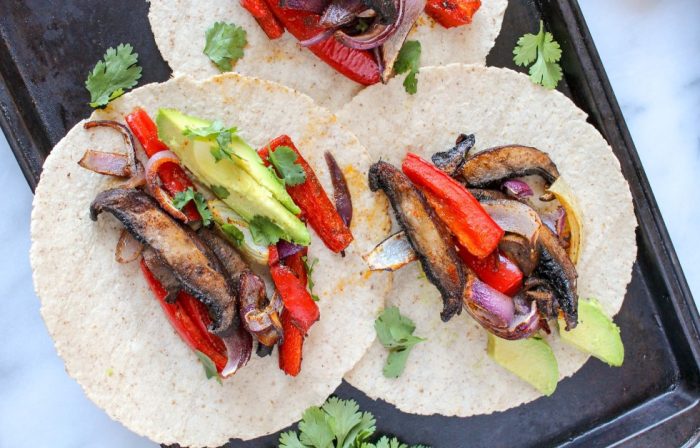 Three mushroom fajitas served on a sheetpan.